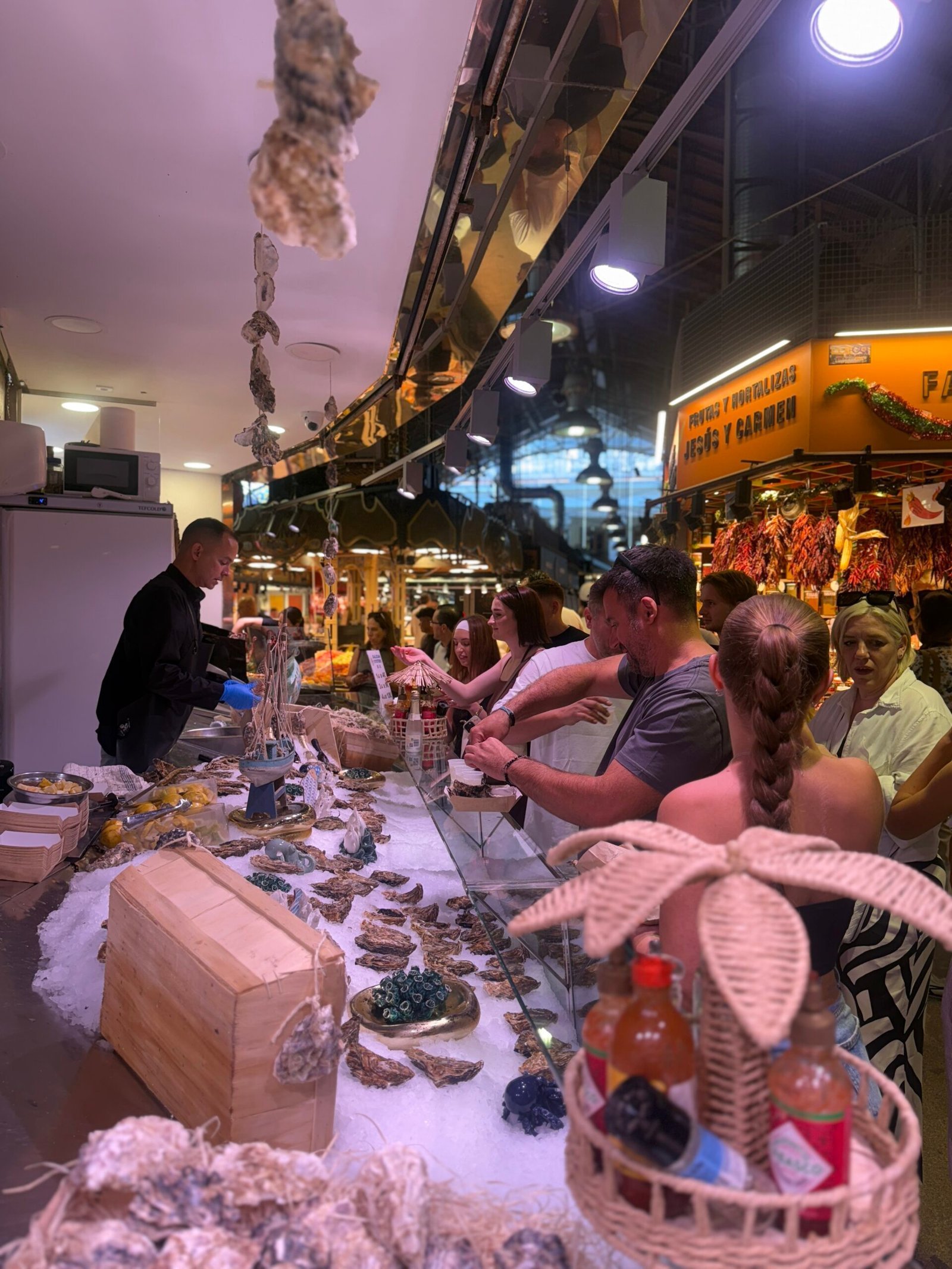 Clientes disfrutando ostras en la barra de OSTRES BCN en La Boqueria, Barcelona